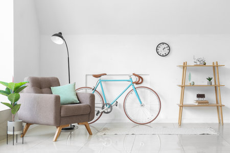 Interior of light living room with armchair, shelving unit and bicycleの写真素材
