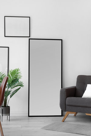Mirror and comfortable armchair in light room interiorの写真素材