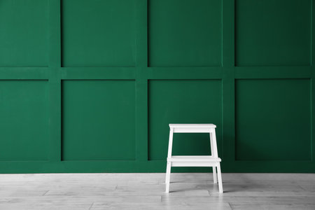 White step stool near green wallの写真素材