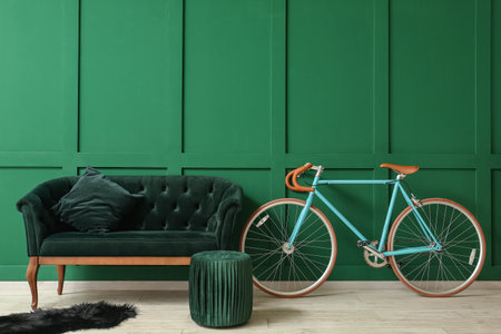 Modern bicycle with sofa and pouf near green wallの写真素材