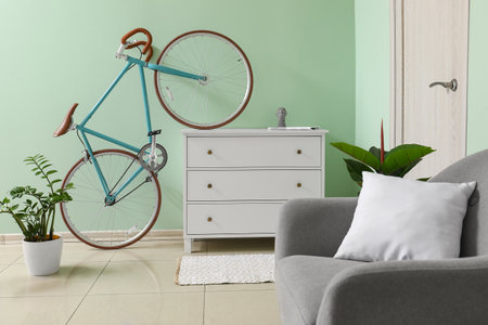 Interior of stylish living room with bicycle, chest of drawers and armchairの写真素材