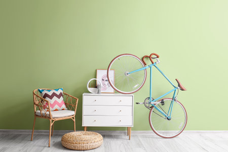 Interior of stylish room with chair, chest of drawers and bicycleの写真素材