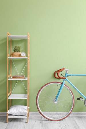 Modern bicycle and shelving unit near green wallの写真素材