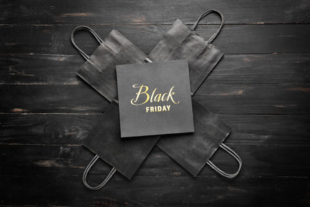 Shopping bags and card with text BLACK FRIDAY on dark background