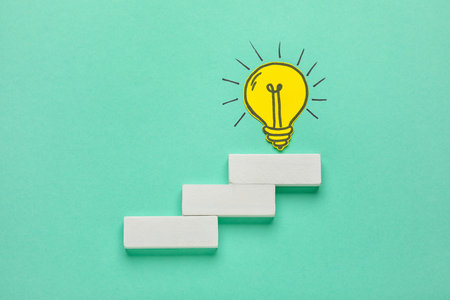 Blocks with paper light bulb on color background