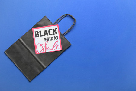 Shopping bag and card with text BLACK FRIDAY SALE on color backgroundの写真素材