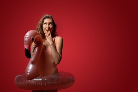Surprised woman with inflatable ring on color backgroundの写真素材