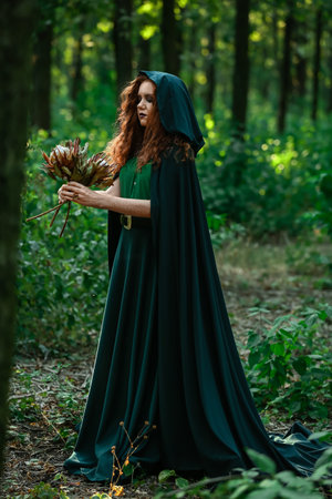 young witch in green forestの写真素材