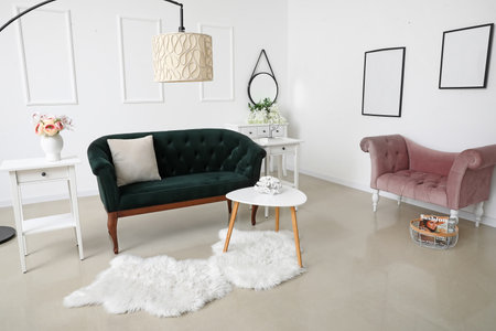 Modern living room interior with stylish sofa, lamp and armchair