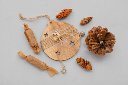 Wooden Christmas decor, pine cones and candies on gray backgroundの写真素材