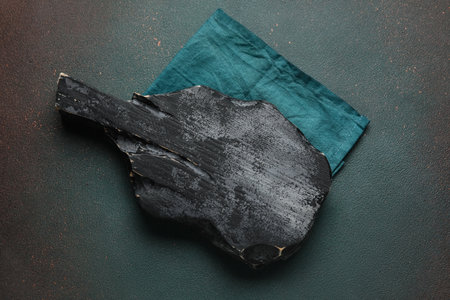 Black wooden cutting board and napkin on dark backgroundの写真素材