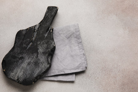 Black wooden cutting board and napkin on grunge backgroundの写真素材