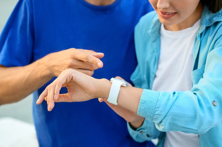 Couple of young tourists with smartwatch outdoors, closeup