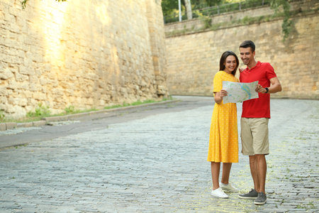 Couple of young tourists with map on city streetの写真素材