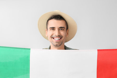 Young man with Italian flag on light backgroundの写真素材
