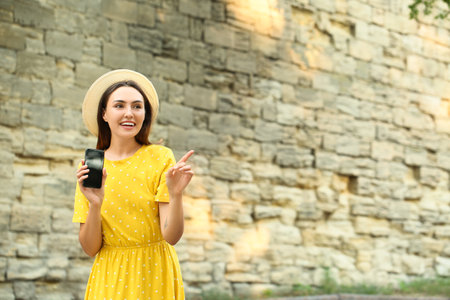 Young woman with phone outdoorsの写真素材