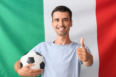 Football fan showing thumb-up against Italian flagの写真素材