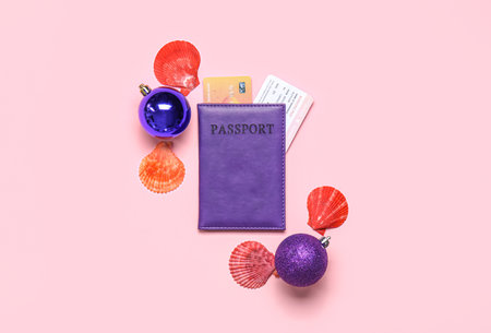 Passport with Christmas balls and seashells on pink backgroundの写真素材