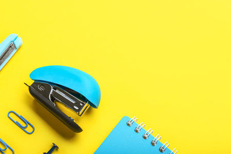 Blue office stapler on yellow backgroundの写真素材
