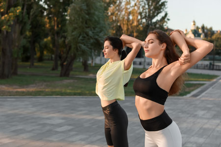 Beautiful young sisters exercising outdoorsの写真素材