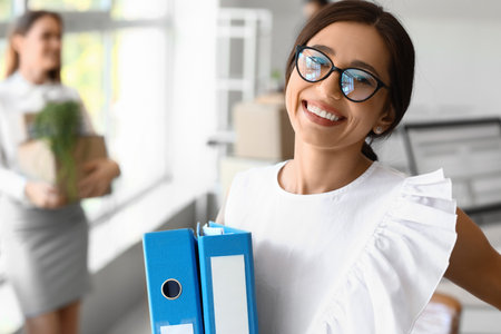 Beautiful woman holding folders in office on moving day, closeupの写真素材