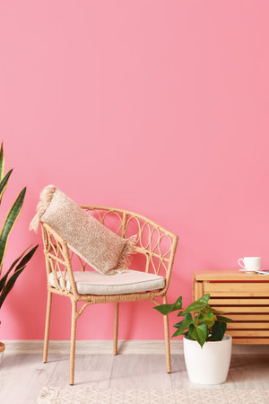 Comfortable chair with pillow near color wall in room interiorの写真素材