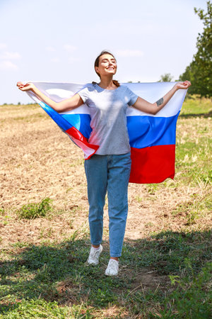 Happy young woman with national flag of Russia outdoorsの写真素材
