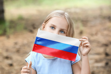 Cute little girl with national flag of Russia in forestの写真素材