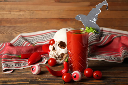 Glass of tasty bloody Mary cocktail decorated for Halloween on wooden backgroundの写真素材