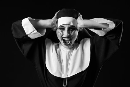 Woman dressed for Halloween as nun on dark backgroundの写真素材