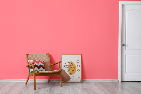 Modern armchair and painting near color wall with door in roomの写真素材