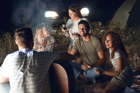 Young people at barbecue party on summer eveningの写真素材