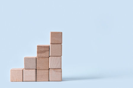 Ladder made of wooden blocks on light background