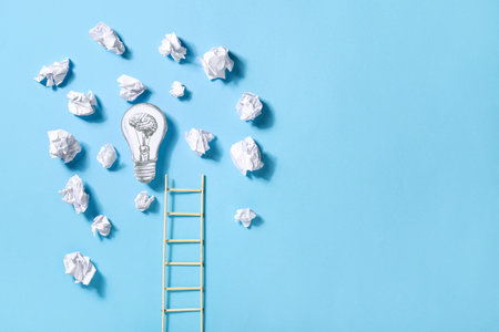 Ladder, light bulb and crumpled paper on color background