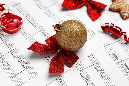 Christmas ball with bow on note sheets, closeupの写真素材
