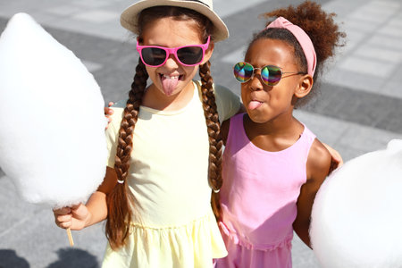 Cute little girls with cotton candy outdoorsの写真素材