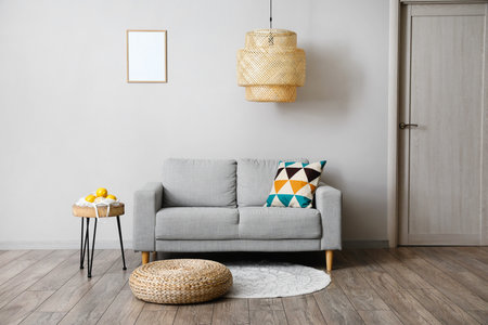 Comfortable sofa, table and modern lamp near gray wallの写真素材