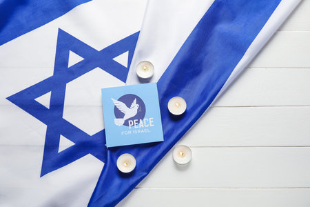 Card with text PEACE FOR ISRAEL, burning candles and flag of Israel on white wooden background
