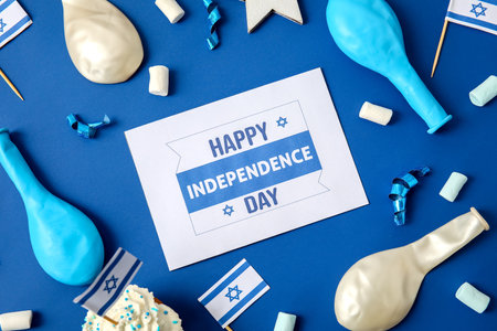 Card with text HAPPY INDEPENDENCE DAY, festive decor and cupcakes on color backgroundの写真素材