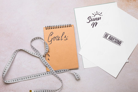 Notebook with empty to do list and measuring tape on gray background. new year goals