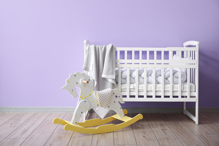 Rocking horse and crib with plaid near color wallの写真素材