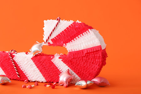 Mexican pinata with candies and balloons on color backgroundの写真素材