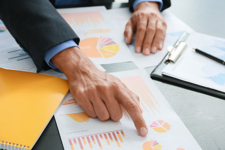 Businessman working with diagrams at desk in office, closeupの写真素材