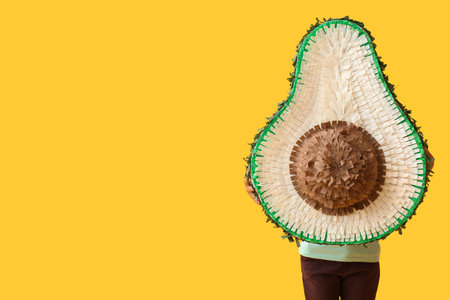 Little boy with Mexican pinata on color background