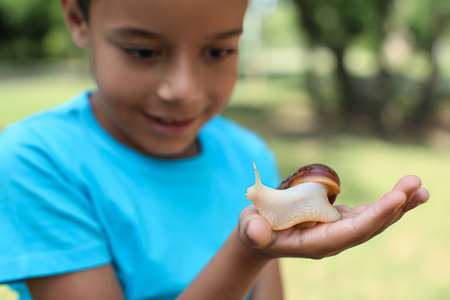 Little boy with snail outdoorsの写真素材