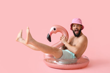 Emotional young man with inflatable ring on color backgroundの写真素材