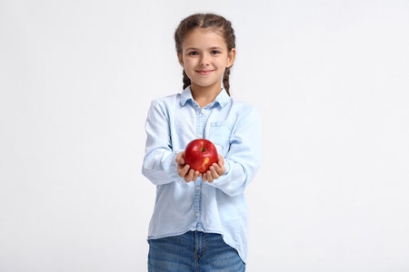 little girl with apple on white backgroundの写真素材