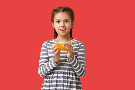 Little girl with honey on color backgroundの写真素材