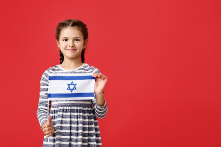 Little girl with the flag of Israel on color backgroundの写真素材
