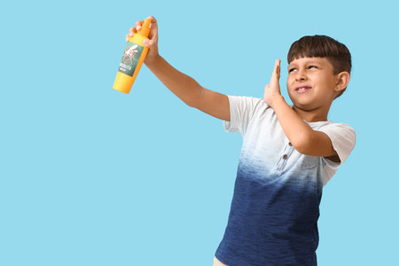 Little boy with mosquito repellent on color backgroundの写真素材